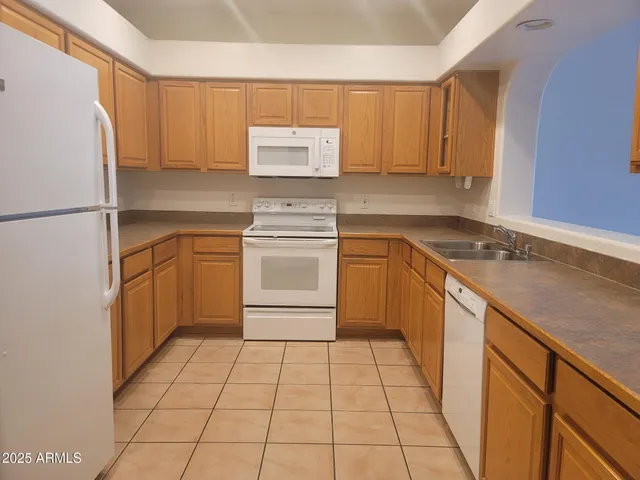 a kitchen with a sink a stove top oven and white cabinets