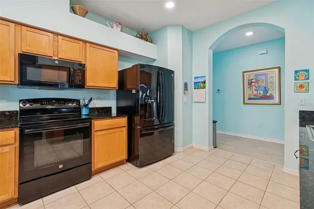 a kitchen with stainless steel appliances granite countertop a refrigerator and a stove top oven