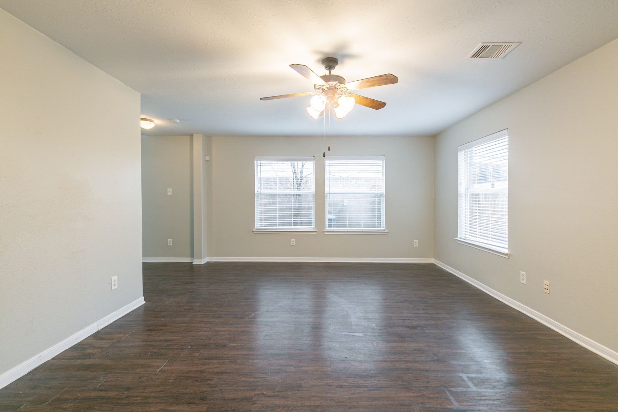 5601 Savannah Woods Lane Rosharon, TX 77583 - Photo 12 of 43 an empty room with wooden floor chandelier fan and windows
