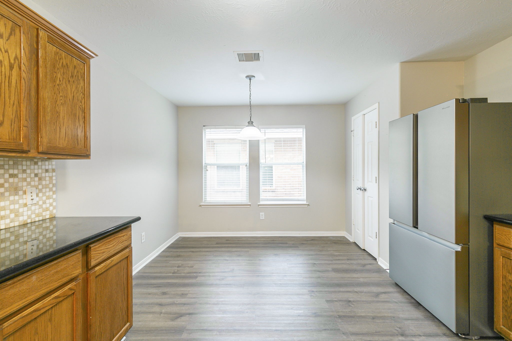5601 Savannah Woods Lane Rosharon, TX 77583 - Photo 16 of 43 a kitchen with stainless steel appliances granite countertop a refrigerator a sink dishwasher and wooden cabinets with wooden floor