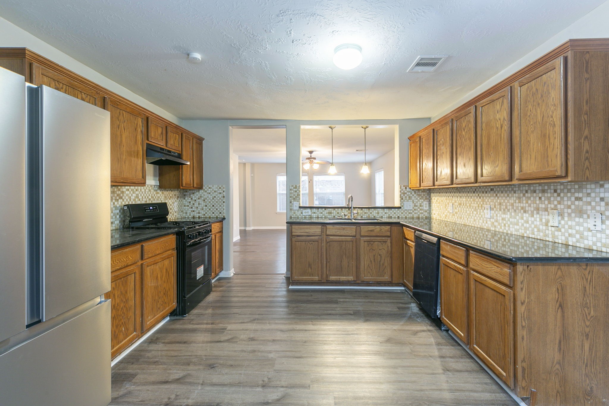 5601 Savannah Woods Lane Rosharon, TX 77583 - Photo 17 of 43 a kitchen with stainless steel appliances kitchen island granite countertop a stove a sink and a refrigerator