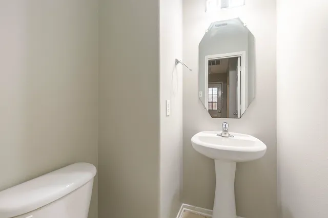 a bathroom with a sink toilet and mirror