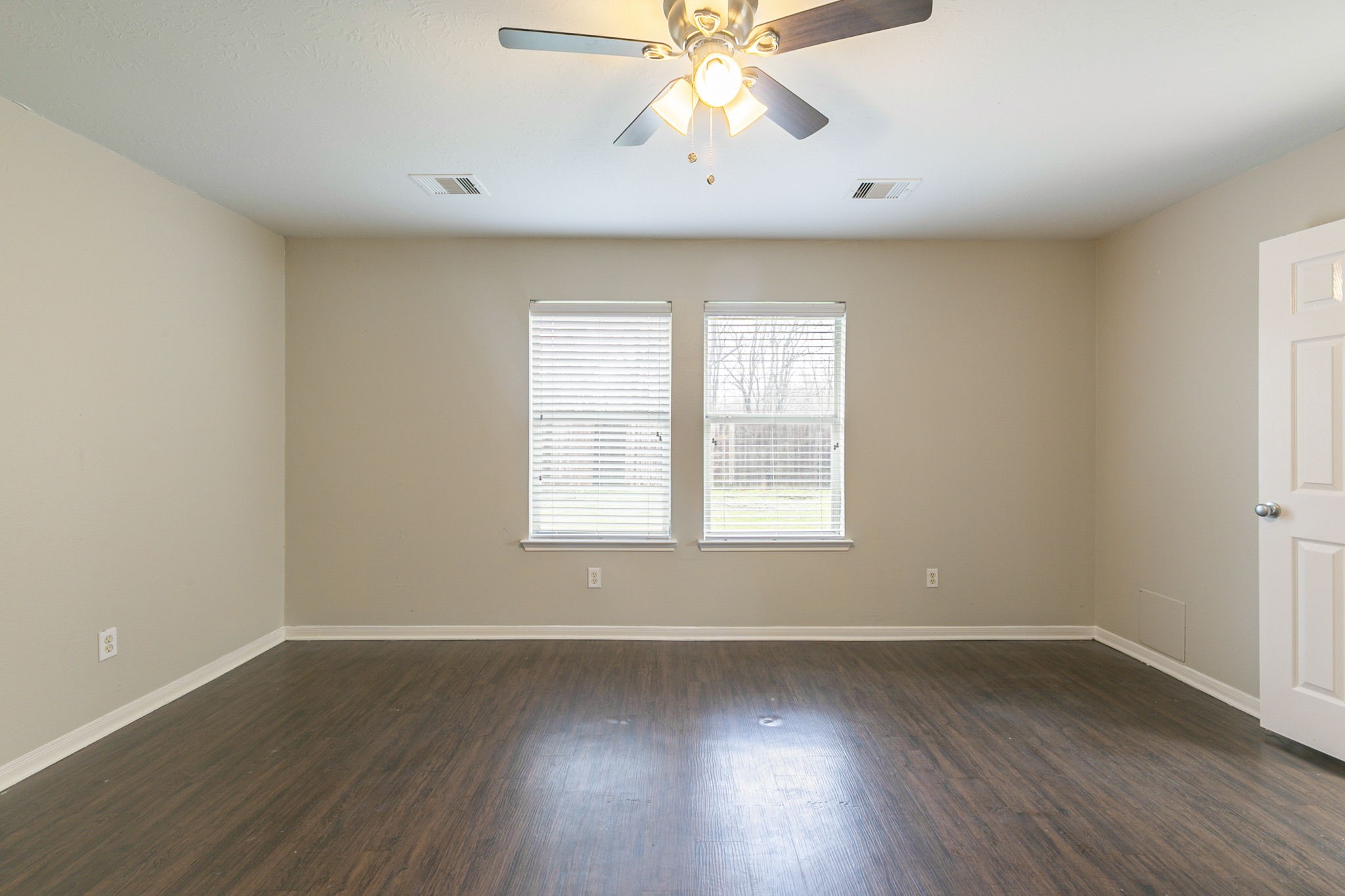 5601 Savannah Woods Lane Rosharon, TX 77583 - Photo 20 of 43 an empty room with wooden floor chandelier fan and windows