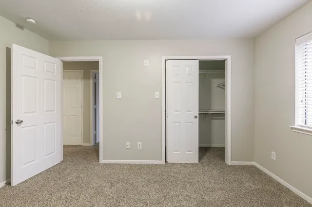 an empty room with windows and closet