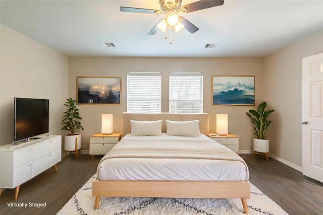 a bedroom with a large bed and a flat tv screen on dresser