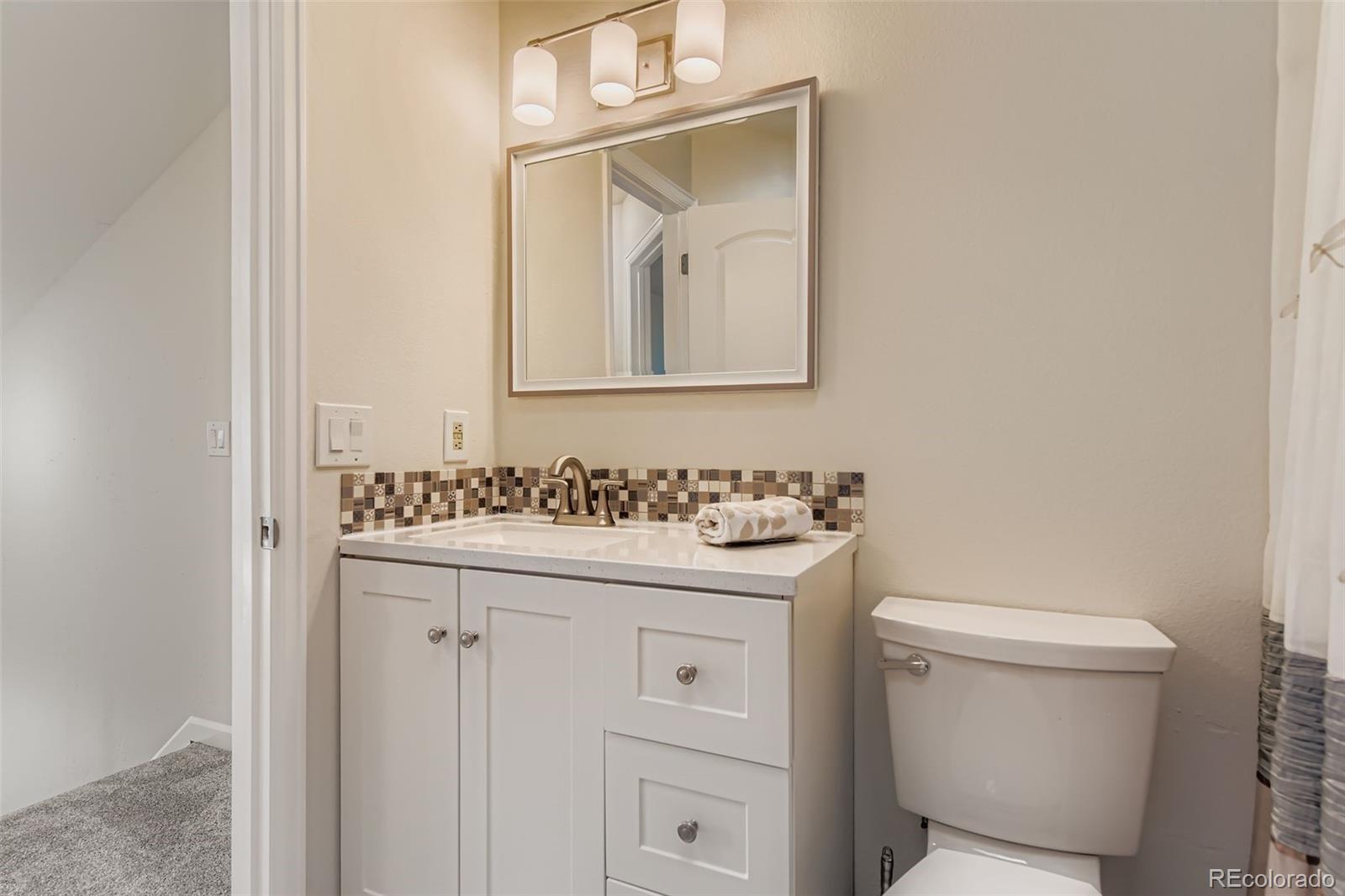 9510 Joyce Lane Highlands Ranch, CO 80126 - Photo 12 of 23 a bathroom with a sink a toilet and mirror