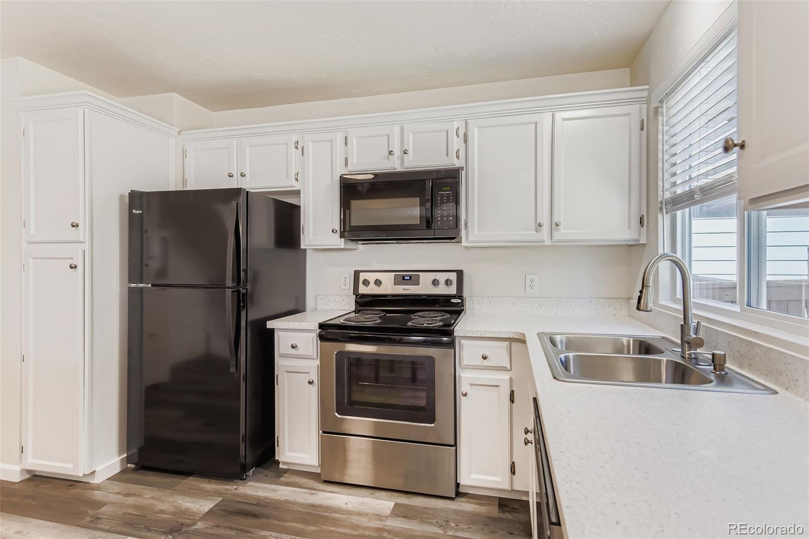 9510 Joyce Lane Highlands Ranch, CO 80126 - Photo 7 of 23 a kitchen with granite countertop a refrigerator stove and microwave
