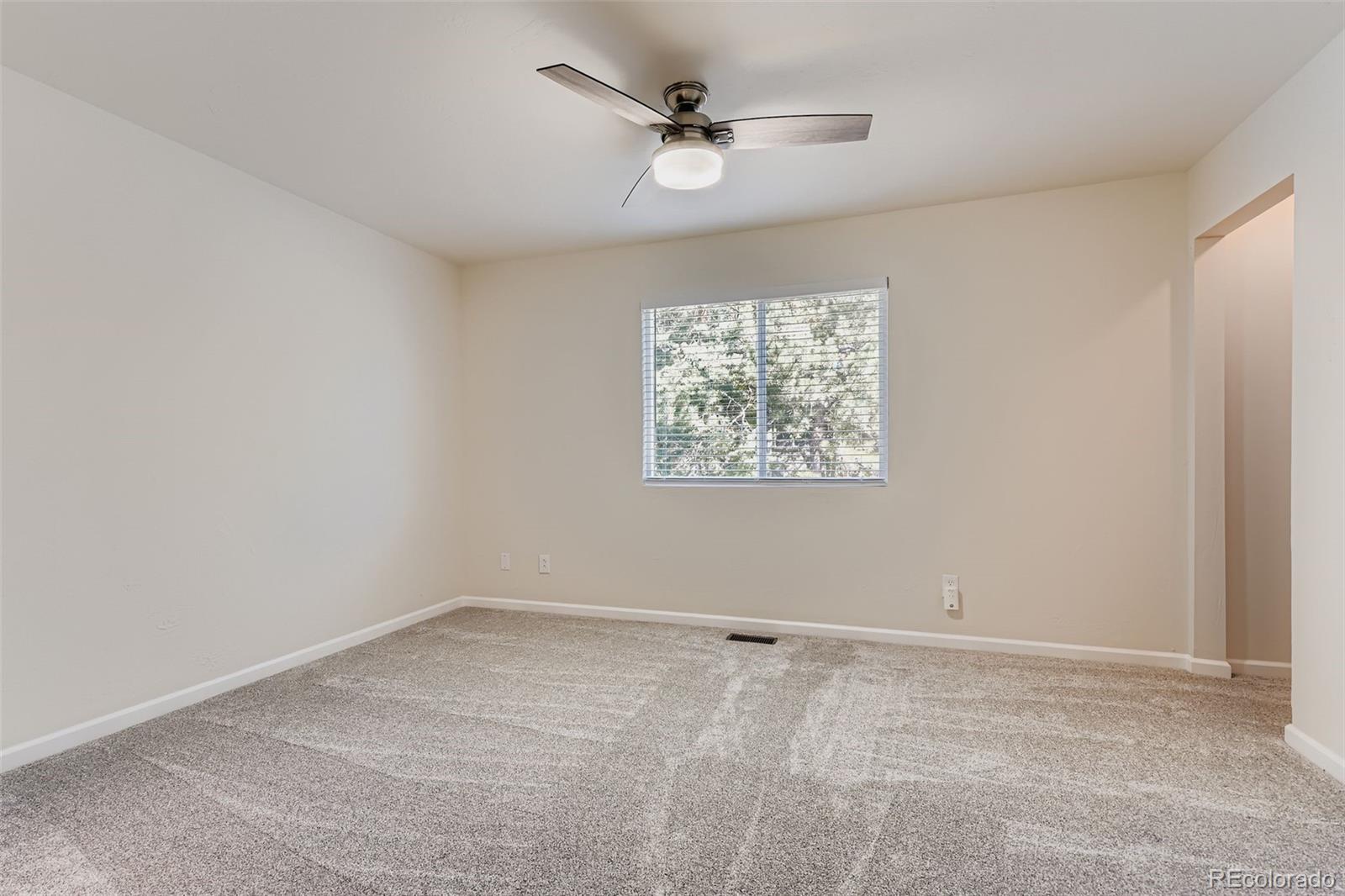 9510 Joyce Lane Highlands Ranch, CO 80126 - Photo 9 of 23 an empty room with a ceiling fan and window