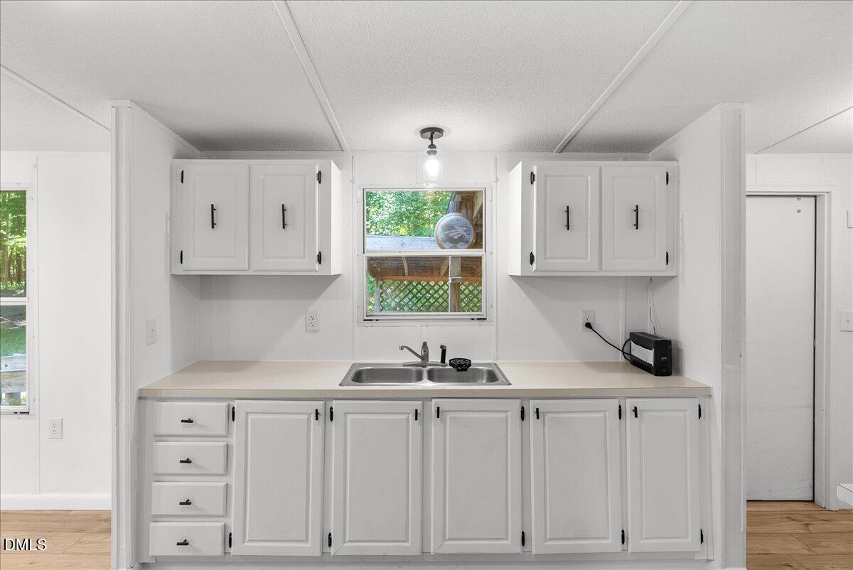 1111 Stoney Mountain Road Rougemont, NC 27572 - Photo 7 of 30 a kitchen with white cabinets and window