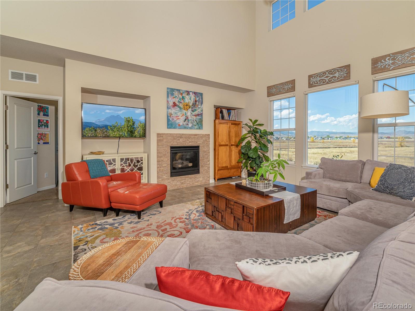 5025 Eagan Circle Longmont, CO 80503 - Photo 11 of 40 a living room with furniture large window and a fireplace