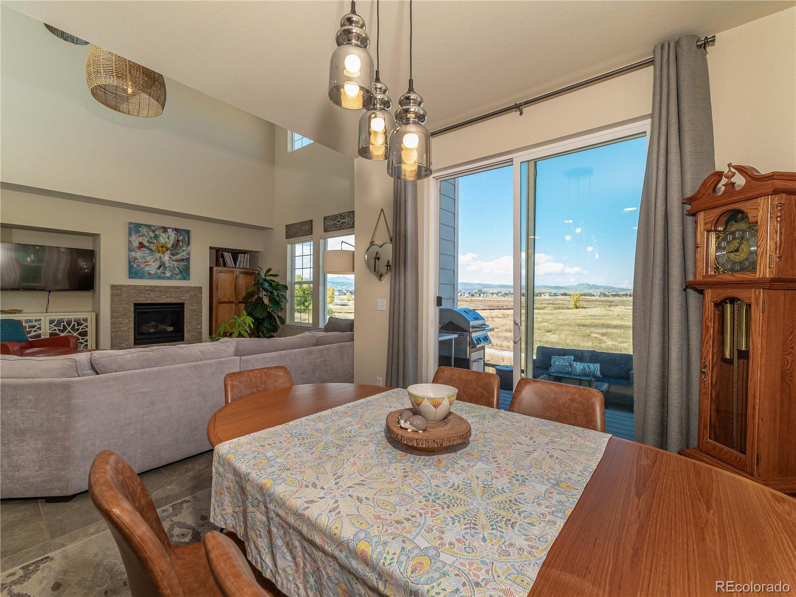 5025 Eagan Circle Longmont, CO 80503 - Photo 14 of 40 a view of a dining room with furniture a chandelier and large windows