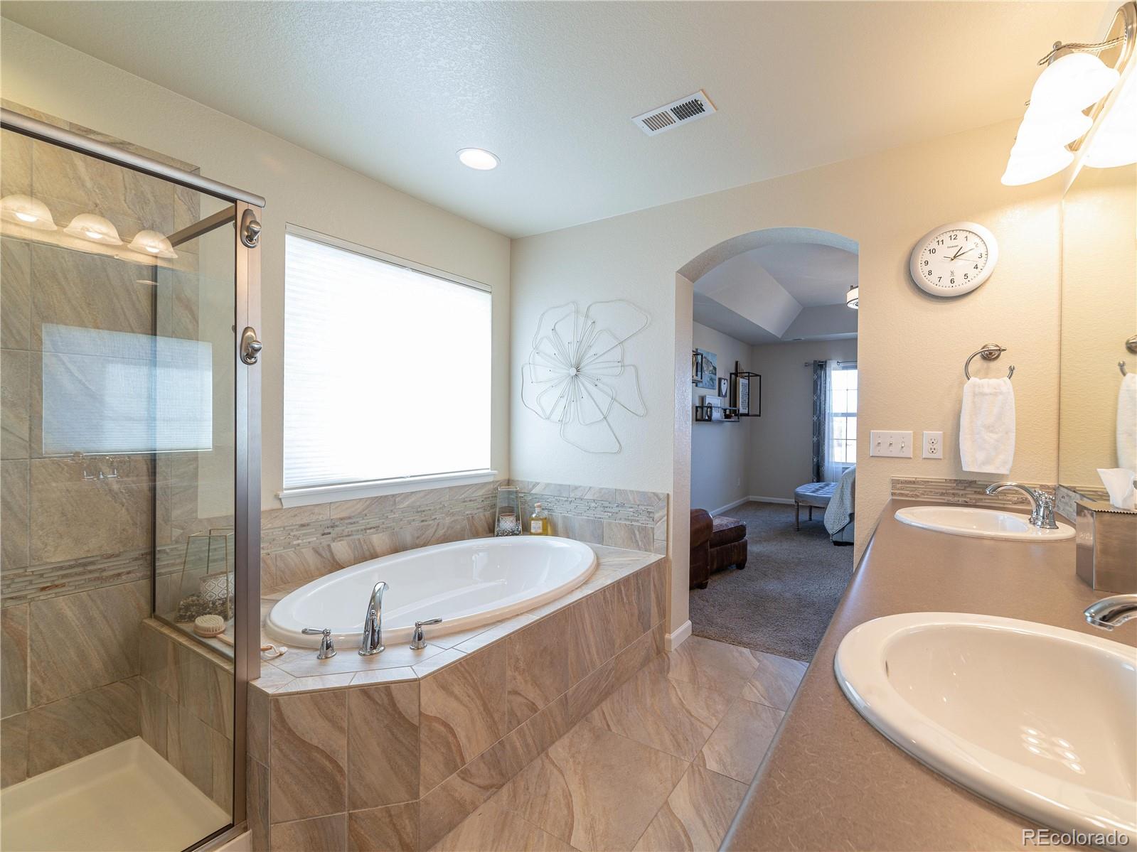 5025 Eagan Circle Longmont, CO 80503 - Photo 20 of 40 a spacious bathroom with a tub sink and mirror