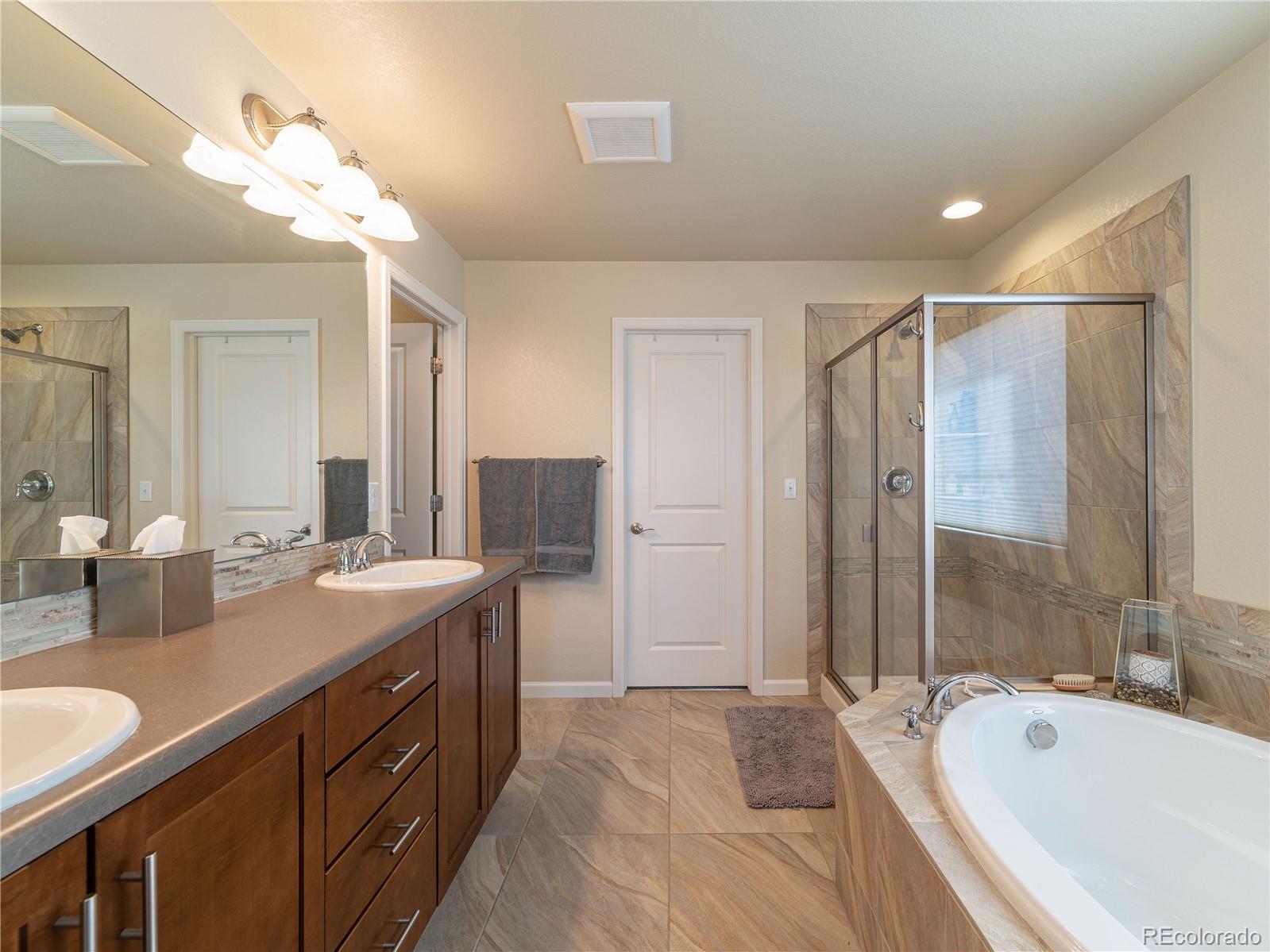 5025 Eagan Circle Longmont, CO 80503 - Photo 21 of 40 a spacious bathroom with a bathtub shower sink double and mirror