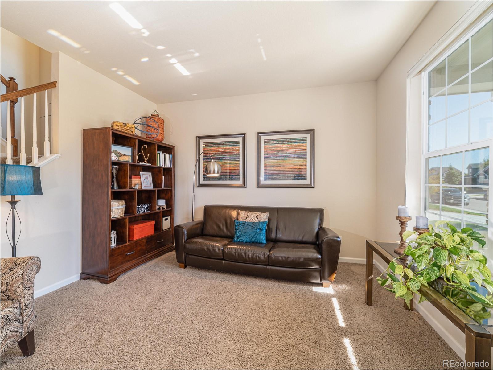 5025 Eagan Circle Longmont, CO 80503 - Photo 3 of 40 a living room with furniture and a potted plant
