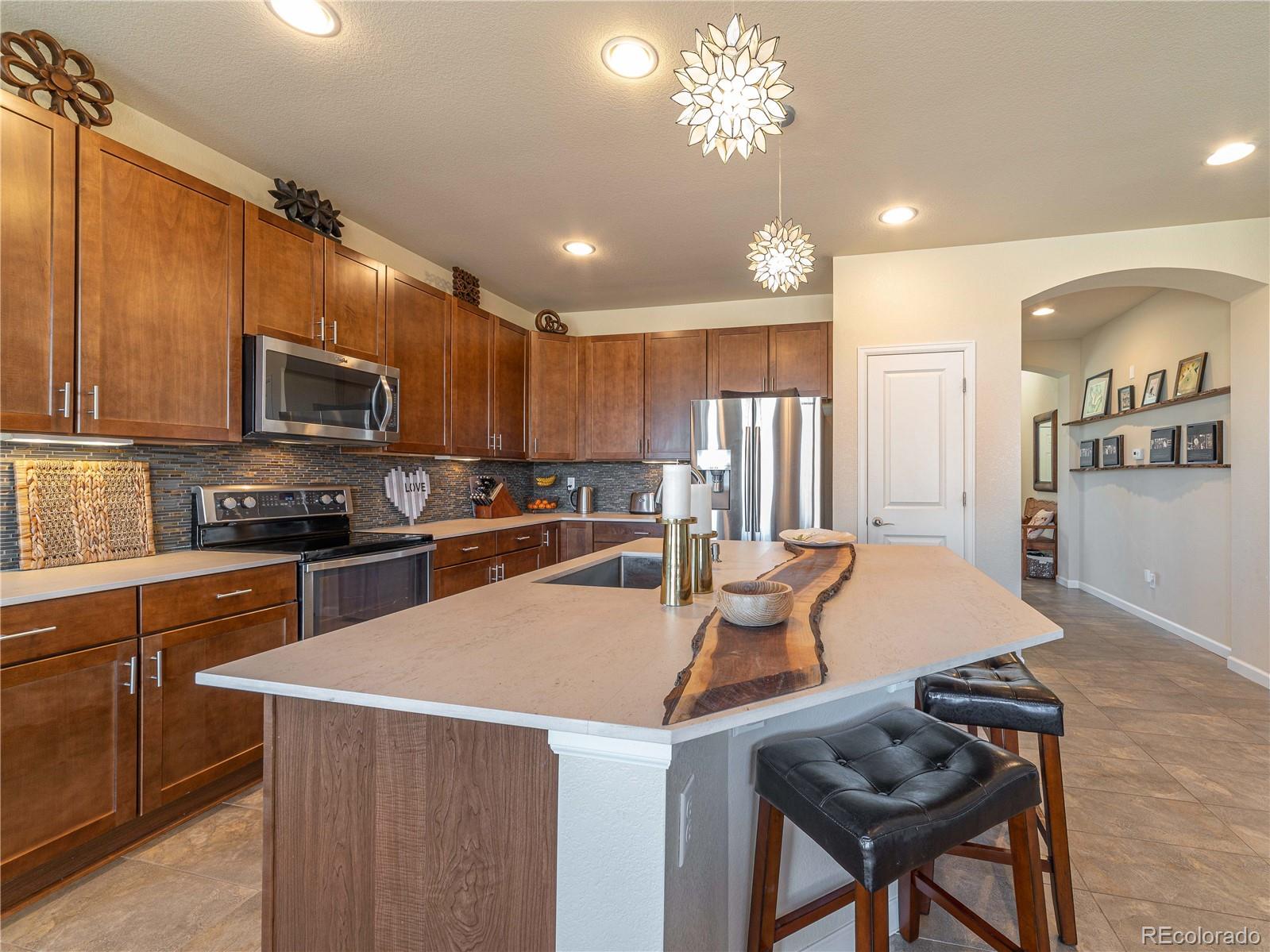 5025 Eagan Circle Longmont, CO 80503 - Photo 7 of 40 a kitchen with granite countertop a stove and a refrigerator