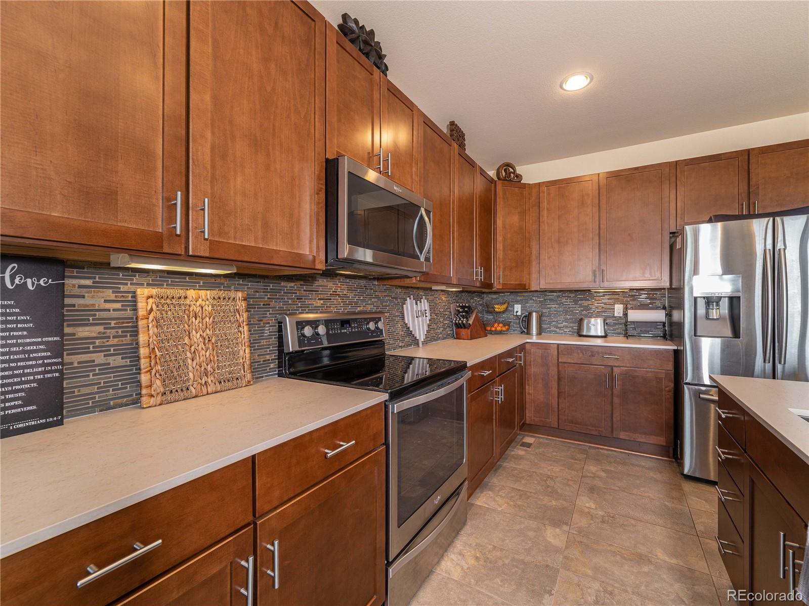 5025 Eagan Circle Longmont, CO 80503 - Photo 8 of 40 a kitchen with stainless steel appliances granite countertop a stove refrigerator and cabinets
