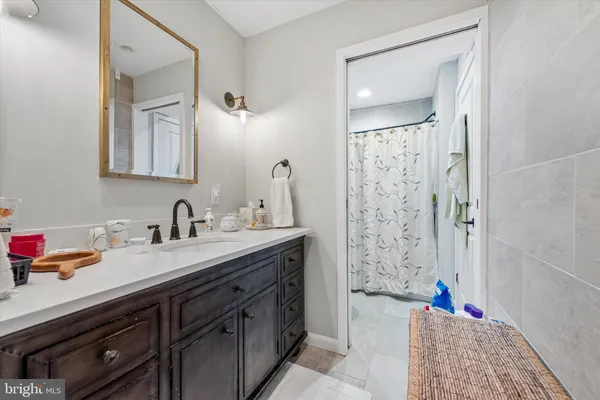 a bathroom with a bathtub sink vanity and mirror