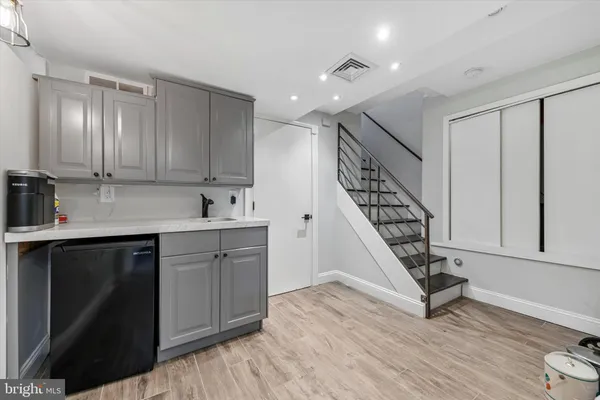 a kitchen with sink cabinets and wooden floor