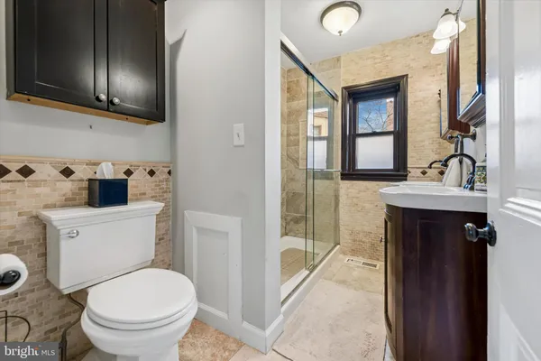 a bathroom with a sink a toilet and shower