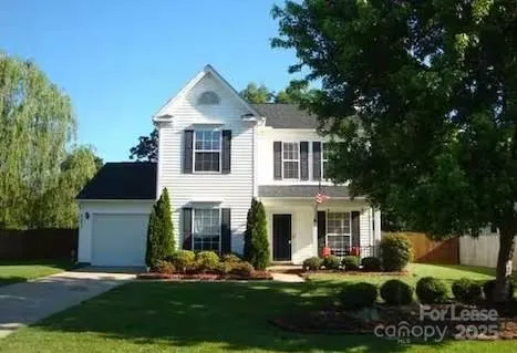 a front view of a house with a yard and trees