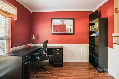 a view of a workspace with furniture and a window