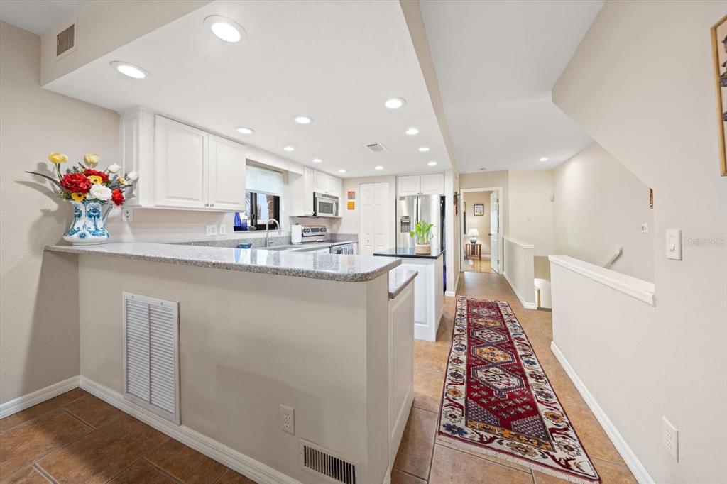 1206 Gulf Boulevard, Unit A6 Indian Rocks Beach, FL 33785 - Photo 13 of 61 a kitchen with stainless steel appliances granite countertop a refrigerator and a sink