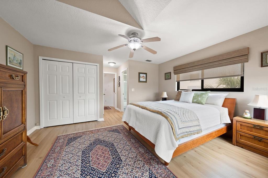 1206 Gulf Boulevard, Unit A6 Indian Rocks Beach, FL 33785 - Photo 20 of 61 a bedroom with a large bed and a chandelier