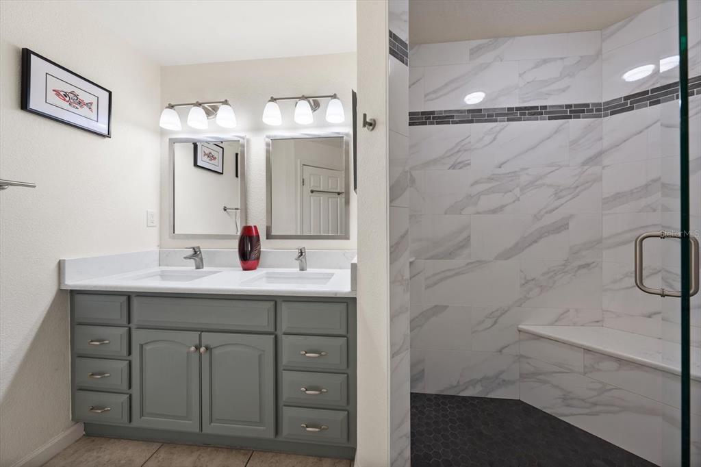 1206 Gulf Boulevard, Unit A6 Indian Rocks Beach, FL 33785 - Photo 23 of 61 a bathroom with a double vanity sink mirror and shower