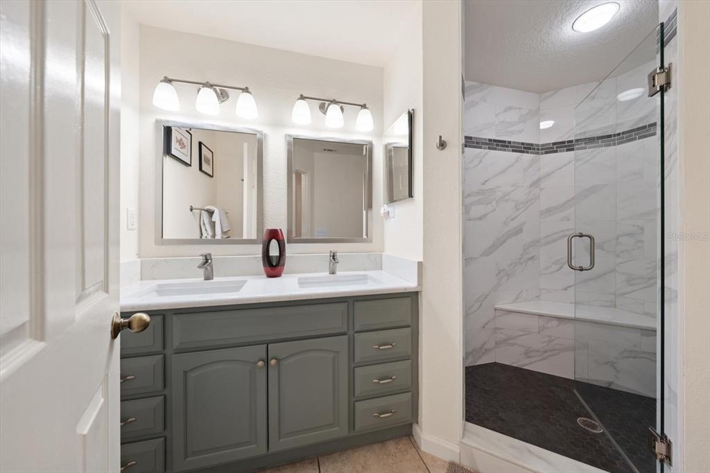 1206 Gulf Boulevard, Unit A6 Indian Rocks Beach, FL 33785 - Photo 24 of 61 a bathroom with a double vanity sink mirror and shower