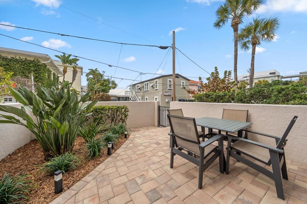 1206 Gulf Boulevard, Unit A6 Indian Rocks Beach, FL 33785 - Photo 33 of 61 a view of a patio with table and chairs and potted plants