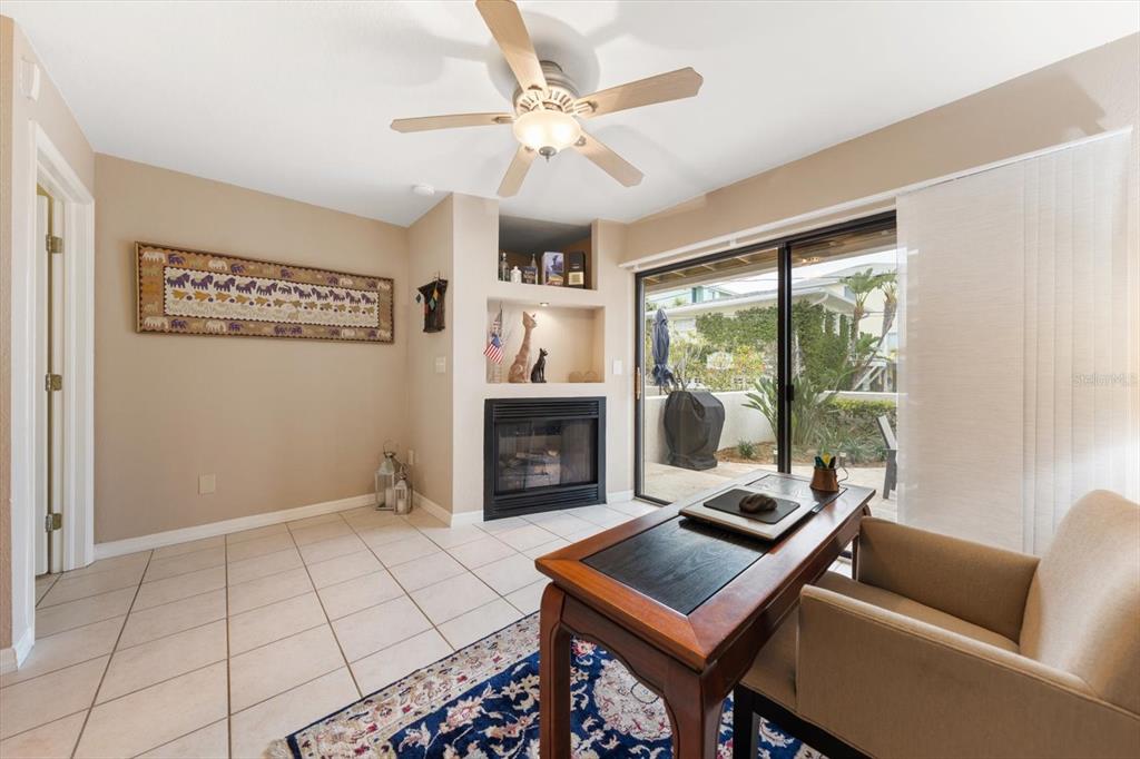 1206 Gulf Boulevard, Unit A6 Indian Rocks Beach, FL 33785 - Photo 37 of 61 a living room with furniture a fireplace and a floor to ceiling window