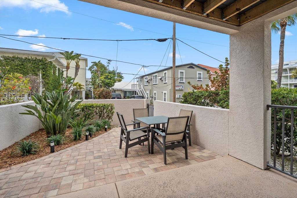 1206 Gulf Boulevard, Unit A6 Indian Rocks Beach, FL 33785 - Photo 38 of 61 a view of a patio with table and chairs and potted plants