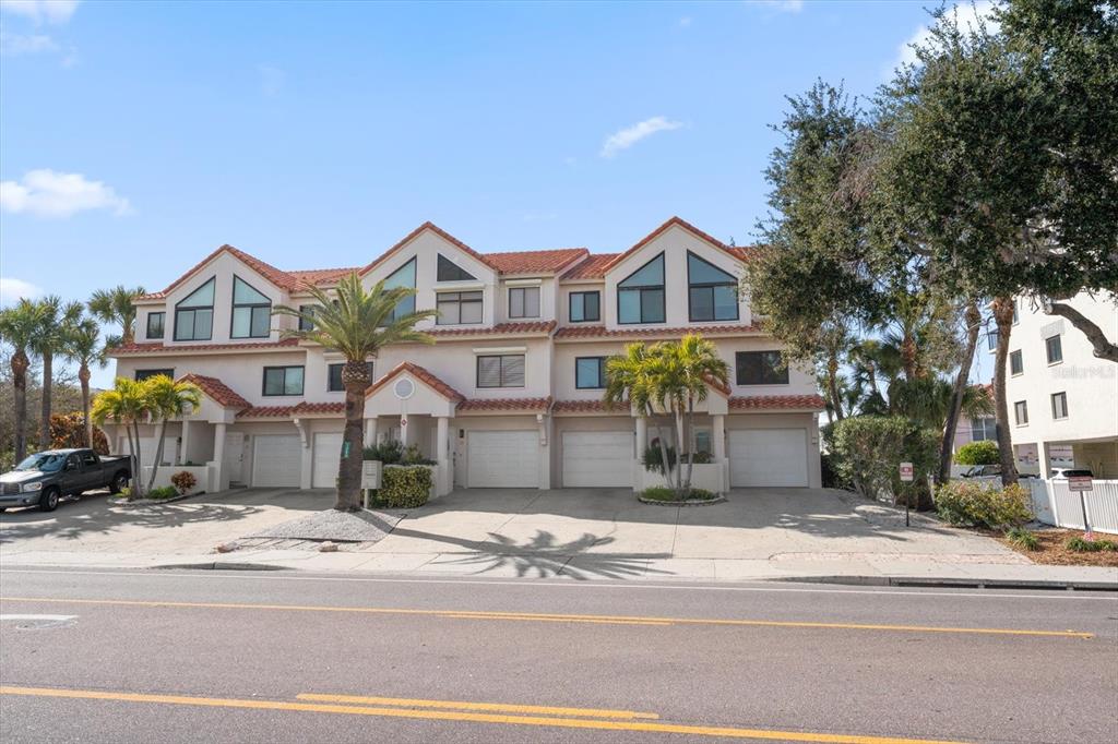 1206 Gulf Boulevard, Unit A6 Indian Rocks Beach, FL 33785 - Photo 49 of 61 a front view of a house with a garden and tree
