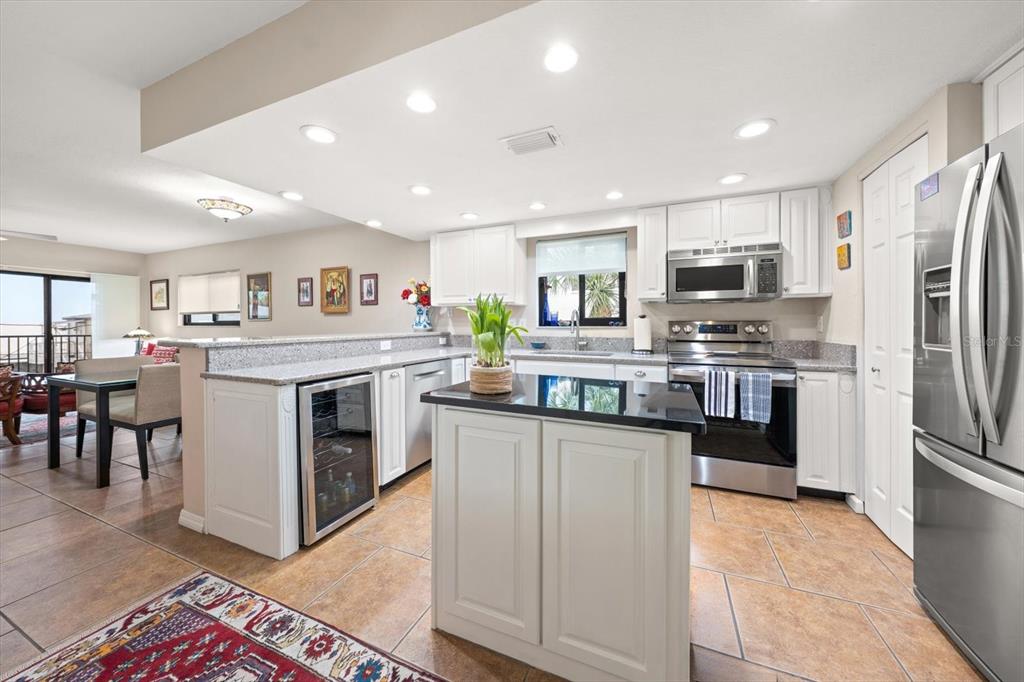 1206 Gulf Boulevard, Unit A6 Indian Rocks Beach, FL 33785 - Photo 8 of 61 a kitchen with stainless steel appliances granite countertop a white cabinets a sink a stove a refrigerator and island