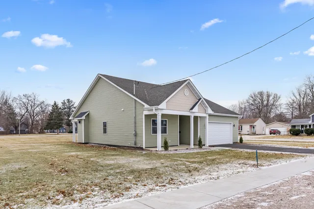 a view of a house with a patio and a yard