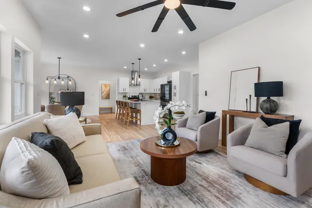 a living room with furniture and a view of kitchen