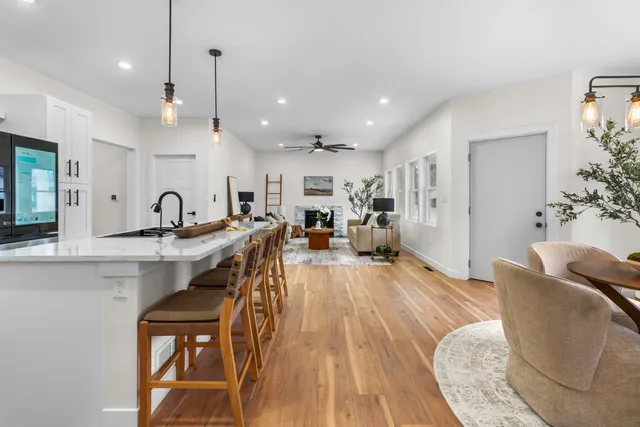 a living room with furniture a wooden floor and a sink