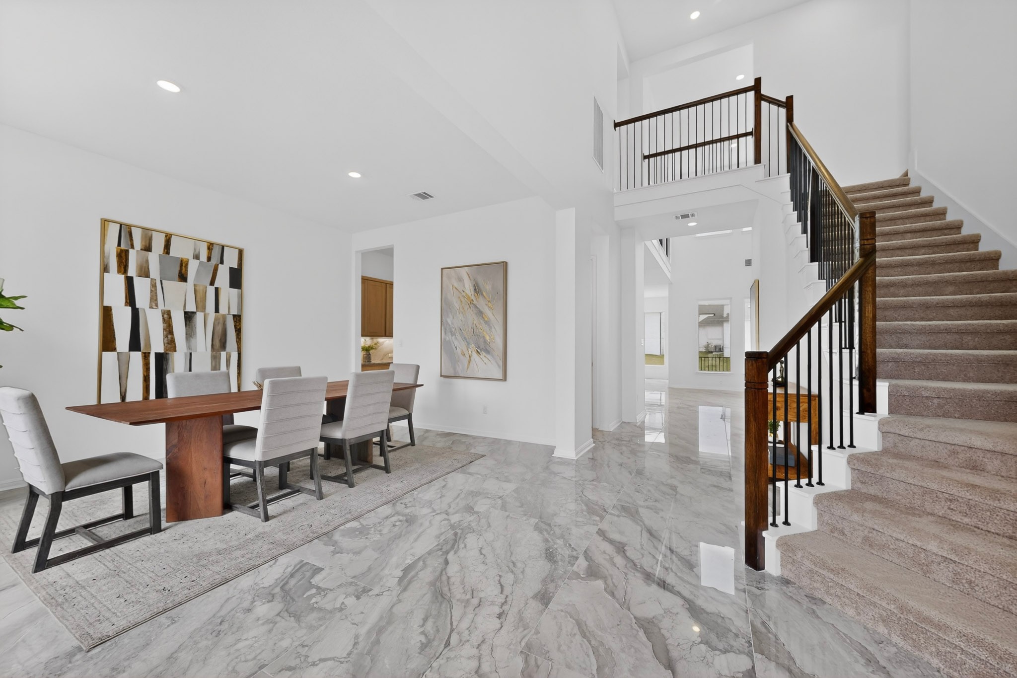2308 Mondello Path Leander, TX 78641 - Photo 3 of 39 Grand foyer with gleaming tile floors flows seamlessly into an elegant dining area, complete with a sweeping staircase to the upper level.