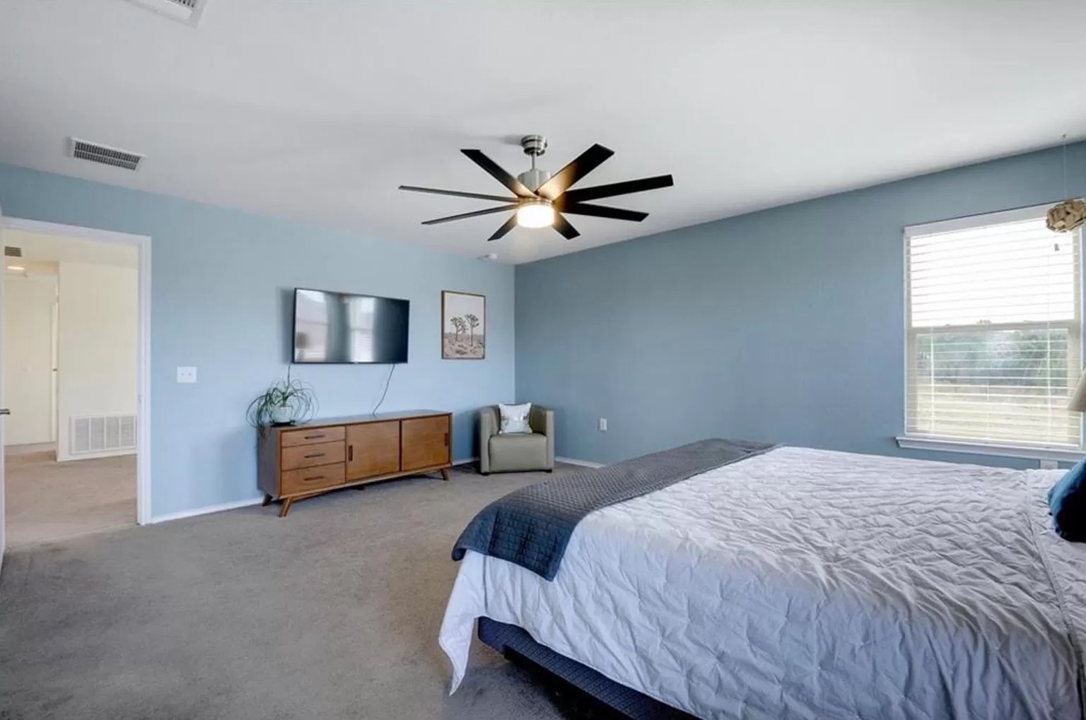 9016 Ridgewell Road Austin, TX 78747 - Photo 16 of 30 A tranquil primary suite offers ample space for rest and rejuvenation, complete with a bright window and soft carpeting.