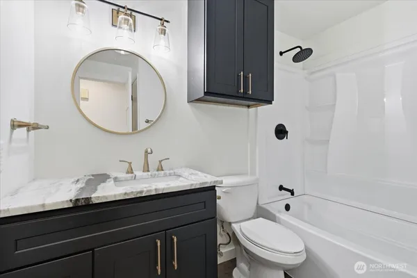 a bathroom with a granite countertop toilet sink and mirror