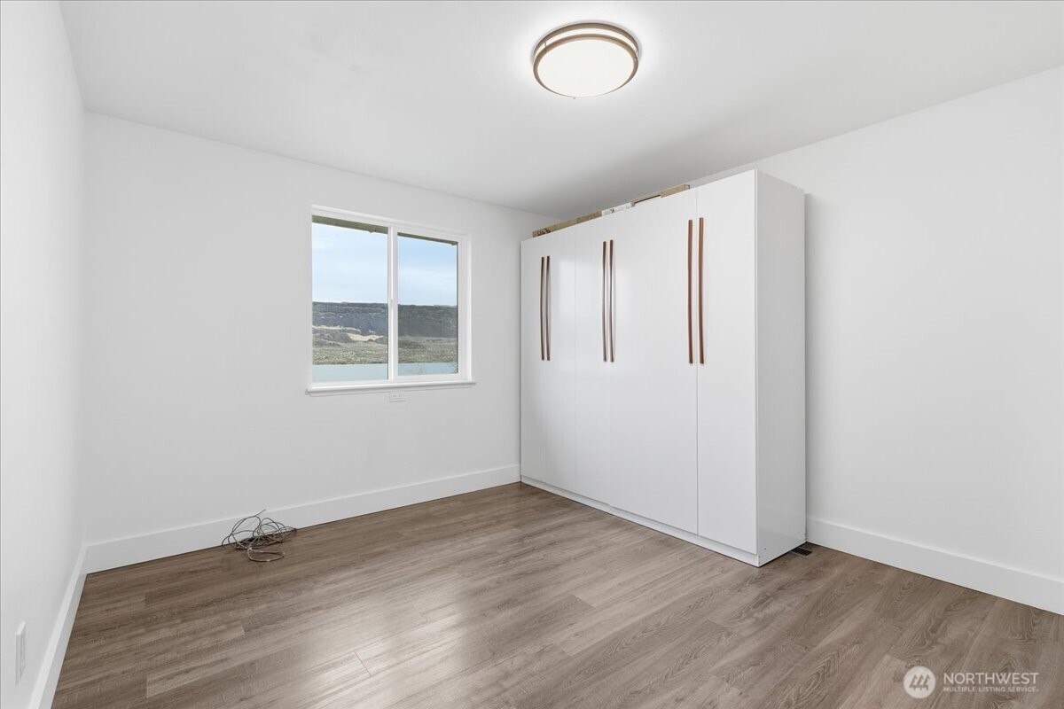 216 Sandy Lane Electric City, WA 99123 - Photo 14 of 40 an empty room with wooden floor and windows