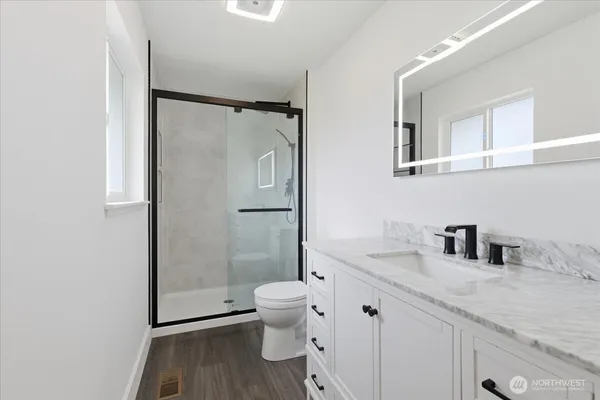 a bathroom with a granite countertop sink toilet and shower