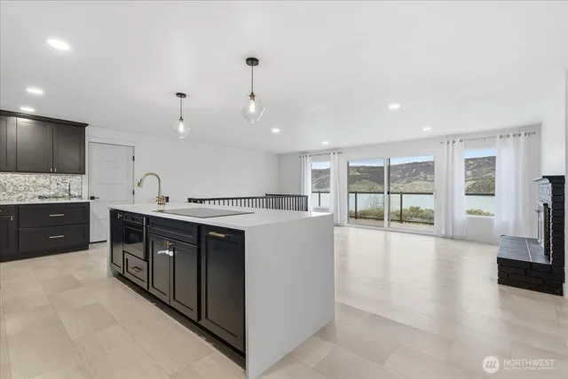 a large kitchen with kitchen island a large counter top stainless steel appliances and cabinets