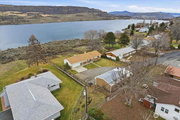 an aerial view of a house with a yard and ocean view