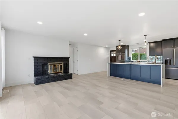a view of kitchen with kitchen island stainless steel appliances cabinets and living room view