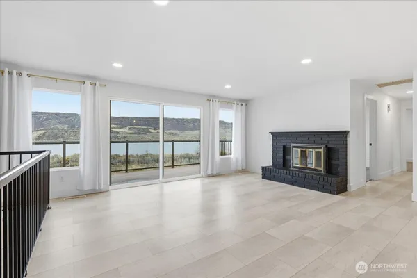 a view of an empty room with a fireplace and a large window