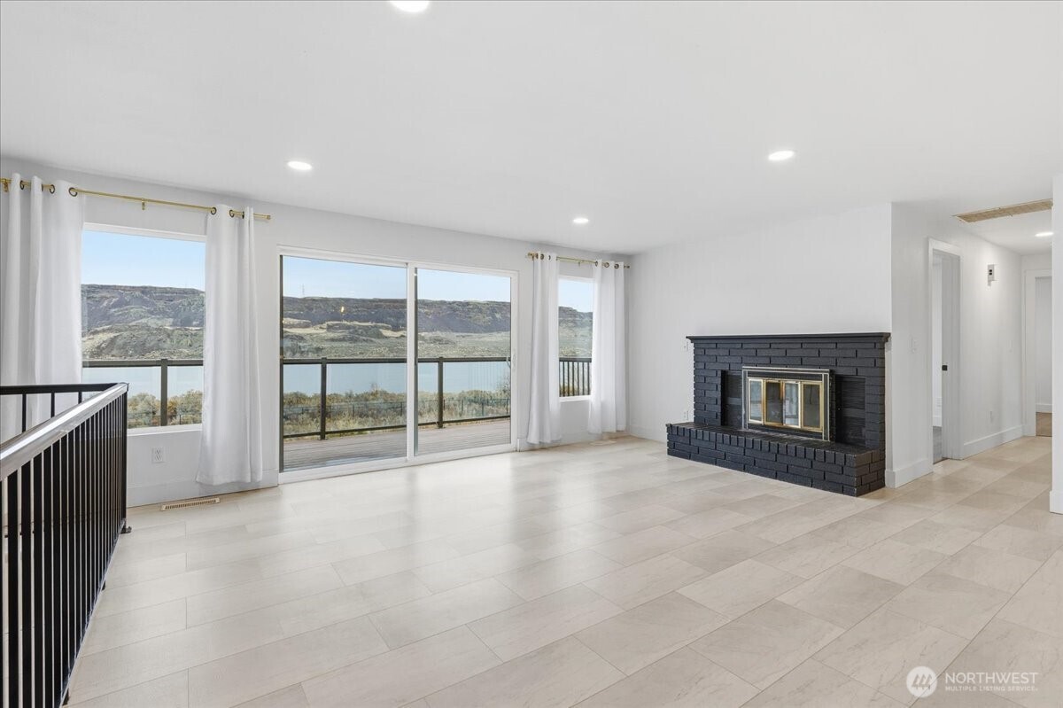 216 Sandy Lane Electric City, WA 99123 - Photo 7 of 40 a view of an empty room with a fireplace and a large window