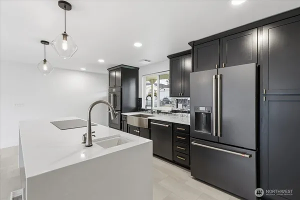 a kitchen with stainless steel appliances a refrigerator sink and cabinets