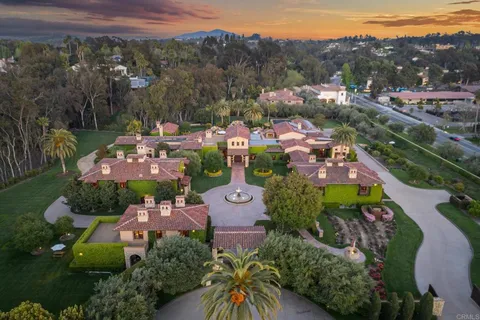 an aerial view of a city with lots of residential buildings and mountain view in back