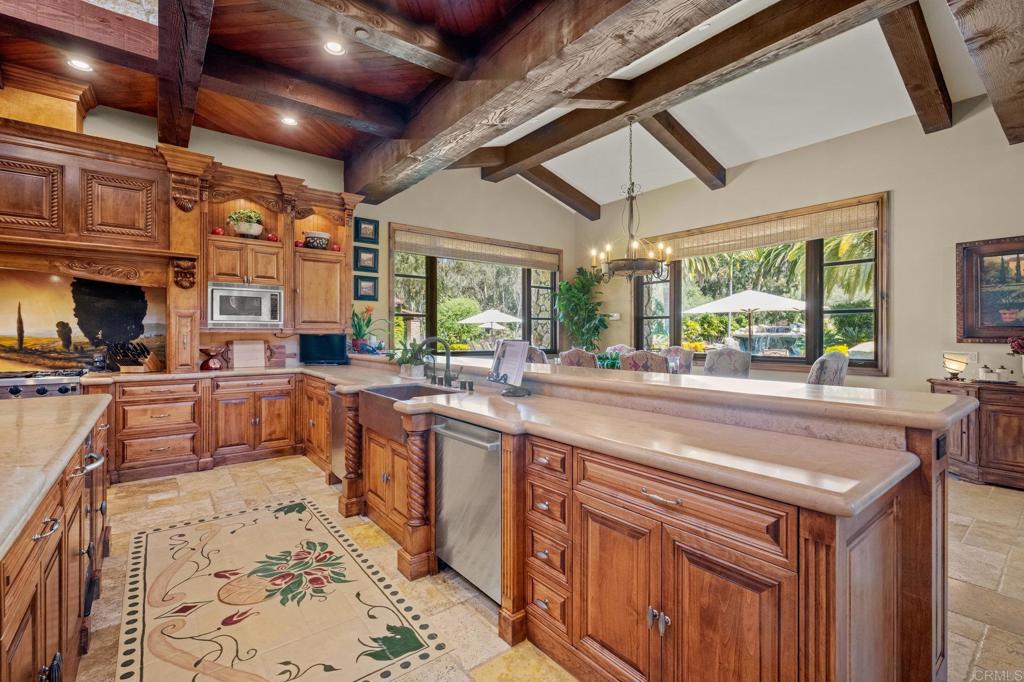 6314 El Apajo Rancho Santa Fe, CA 92067 - Photo 27 of 60 a kitchen with stainless steel appliances kitchen island granite countertop a sink and wooden cabinets